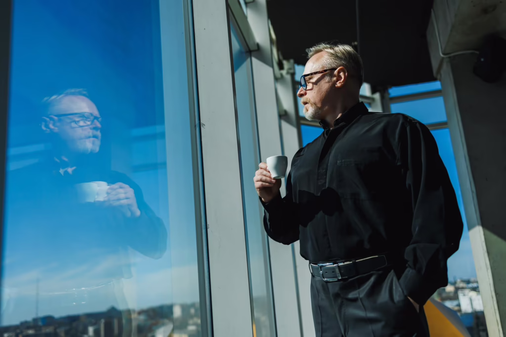 An executive standing in front of a window, considering the EB-5 visa pathway